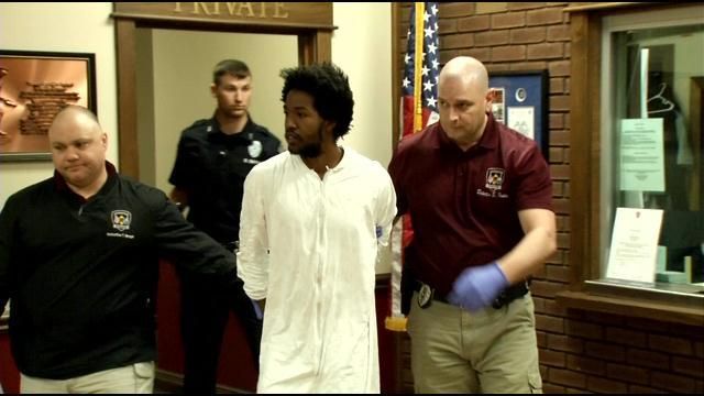 Ronshai Jenefor is escorted out of the Jeffersontown Police Department to be taken to Metro Corrections.